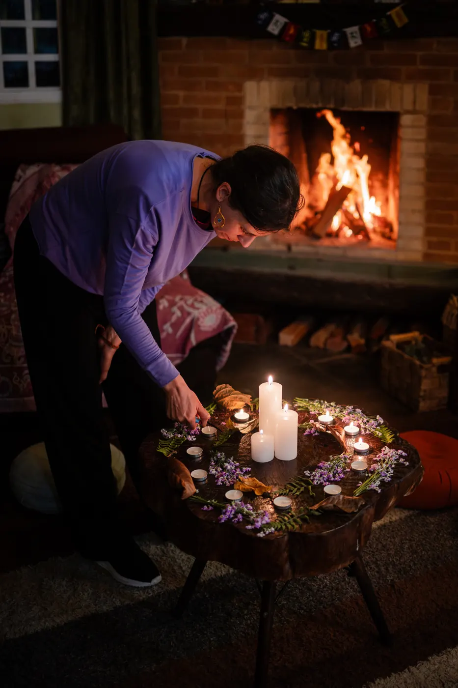 Ritual com velas e flores à luz da lareira