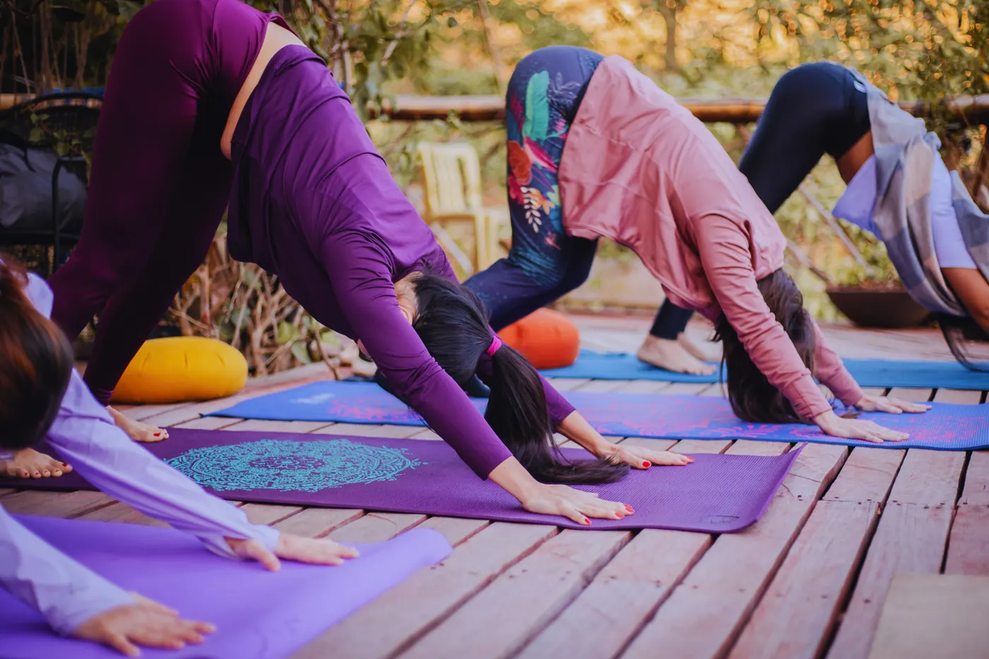 Mulheres praticando yoga em um deck de madeira